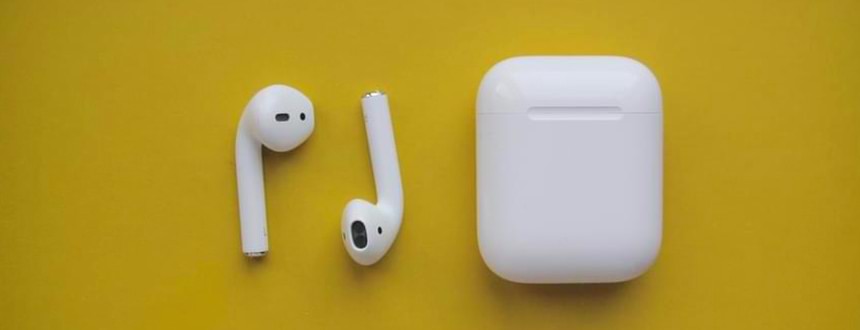 A pair of AirPods in front of a yellow background, one of the most popular mobile accessories of all time.