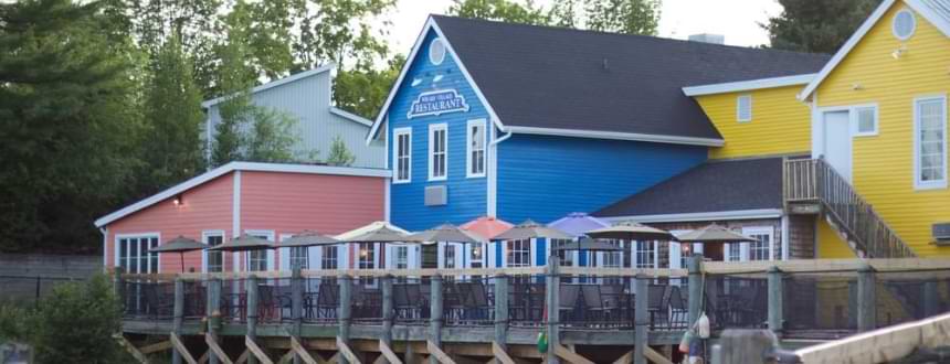 Trois maisons colorées dans la campagne du Nouveau-Brunswick. où Rogers Internet sera bientôt largement disponible.