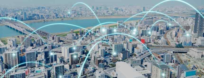 Une vue de la ville avec des lignes bleu vif reliant les bâtiments entre eux, représentant les différents types d'internet qui alimentent le débat DSL vs câble vs fibre optique.