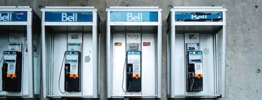 Quatre téléphones publics de Bell côte à côte - sont-ils les vainqueurs du débat Telus vs Bell ?