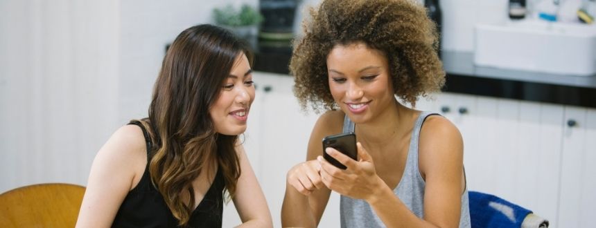Recommander un ami : 2 femmes qui regardent un téléphone